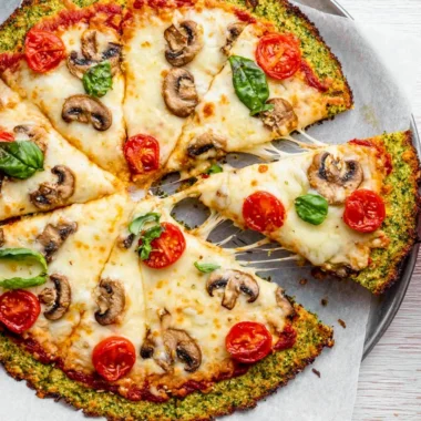 Broccoli pizza crust topped with fresh vegetables and cheese