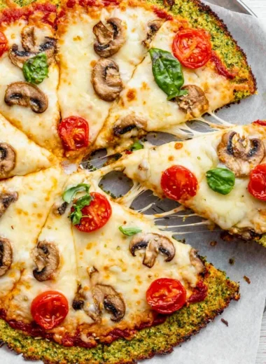 Broccoli pizza crust topped with fresh vegetables and cheese
