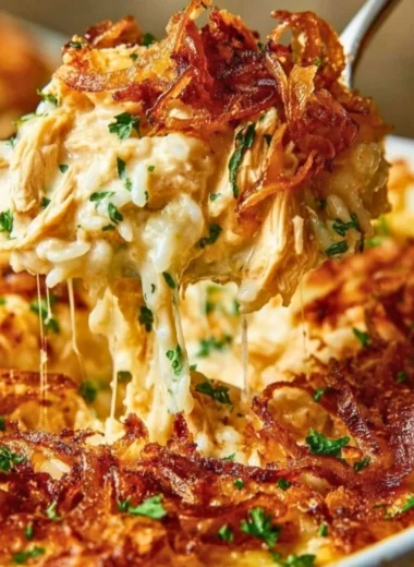 Creamy French onion chicken served over a bed of rice, garnished with herbs.