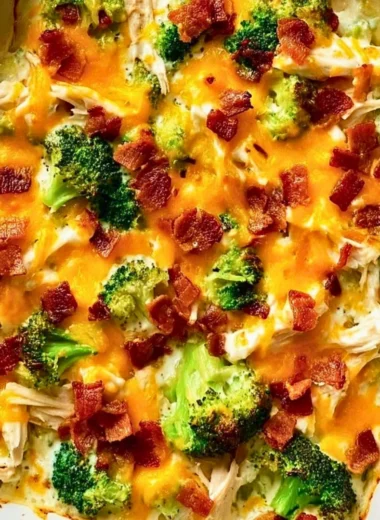 Creamy low carb chicken casserole topped with cheese and herbs in a baking dish.