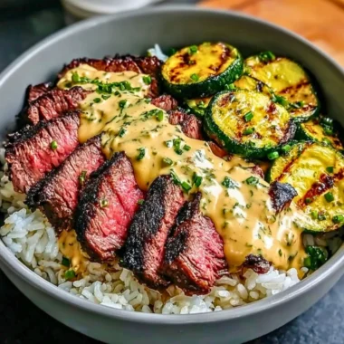Grilled steak bowl with sauce and grilled zucchini on a plate