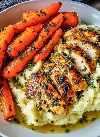 Delicious Garlic Herb Chicken served with mashed potatoes and glazed carrots