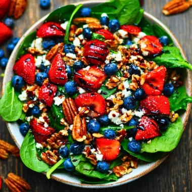 Fresh strawberry spinach salad with dressing on a plate