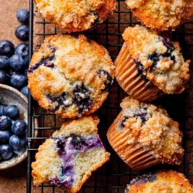 Bakery style blueberry muffins fresh out of the oven with blueberries on top