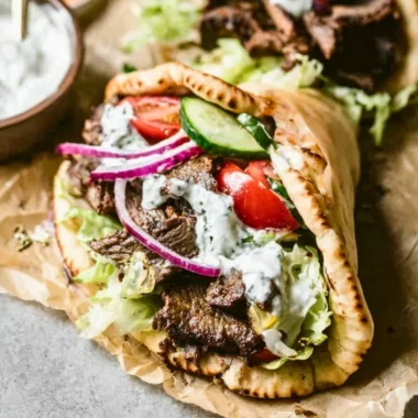 Plate of homemade Beef Gyros with fresh vegetables and tzatziki sauce