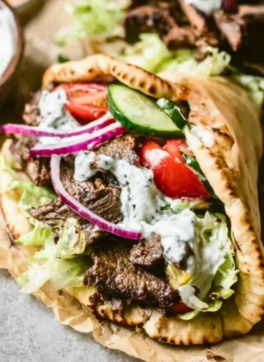 Plate of homemade Beef Gyros with fresh vegetables and tzatziki sauce
