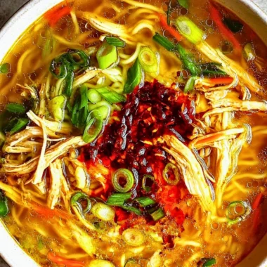 Bowl of Classic Ginger Garlic Chicken Noodle Soup garnished with herbs