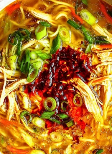 Bowl of Classic Ginger Garlic Chicken Noodle Soup garnished with herbs