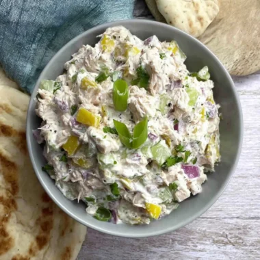 Cottage cheese chicken salad with banana peppers in a bowl garnished with herbs