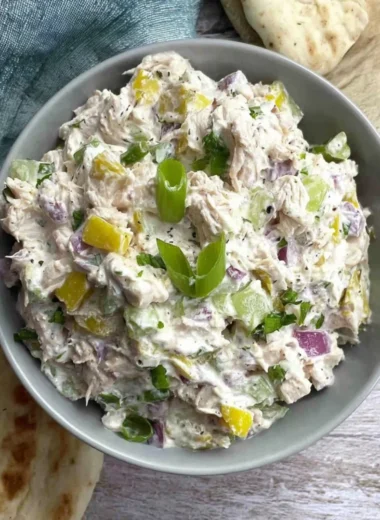 Cottage cheese chicken salad with banana peppers in a bowl garnished with herbs