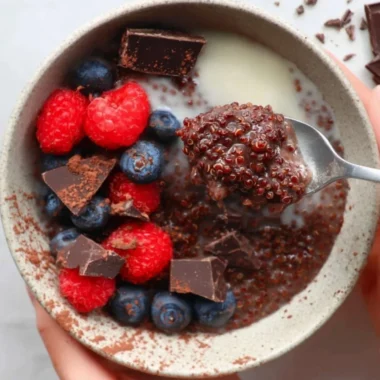 Delicious dark chocolate quinoa breakfast bowl topped with fresh fruits and nuts