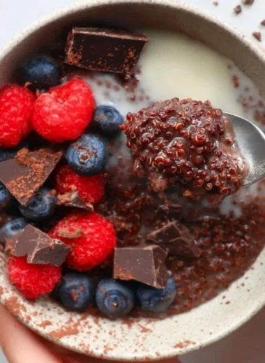 Delicious dark chocolate quinoa breakfast bowl topped with fresh fruits and nuts