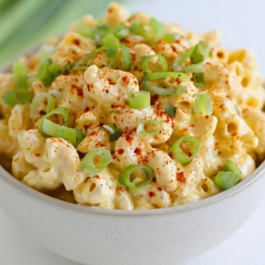Delicious deviled egg pasta salad served in a bowl with fresh ingredients.