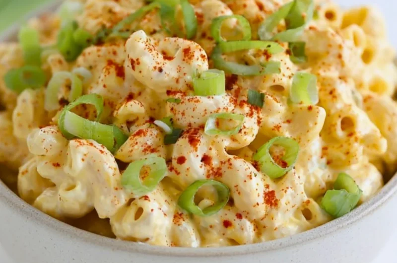 Delicious deviled egg pasta salad served in a bowl with fresh ingredients.