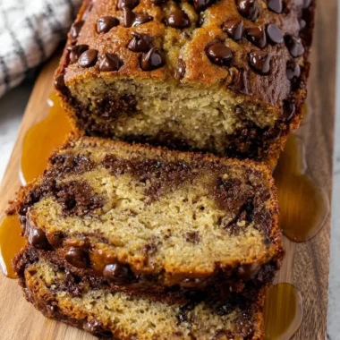 Loaf of easy chocolate chip banana bread sliced on a cutting board