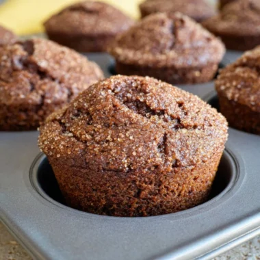 Gingerbread muffins topped with a zesty lemon glaze on a rustic background.