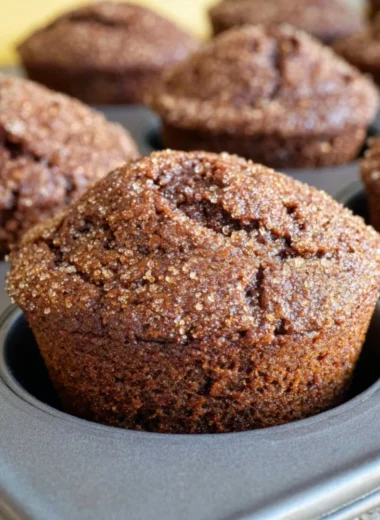 Gingerbread muffins topped with a zesty lemon glaze on a rustic background.