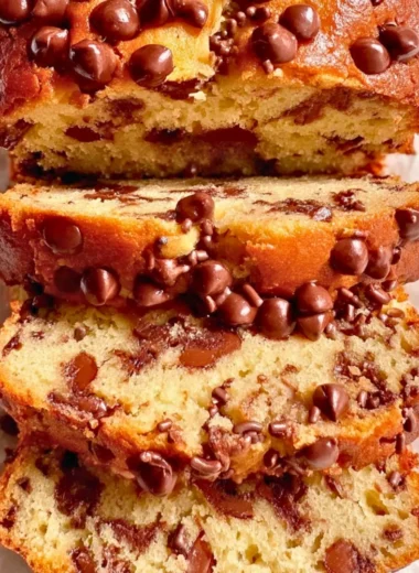 A slice of moist Greek Yogurt Cake on a plate with fresh berries
