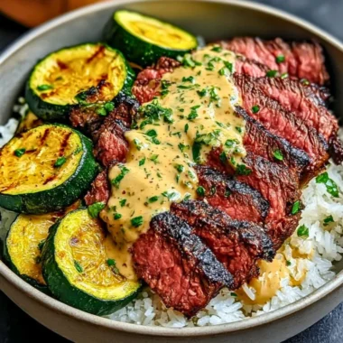 Delicious grilled steak bowl topped with sauce and grilled zucchini