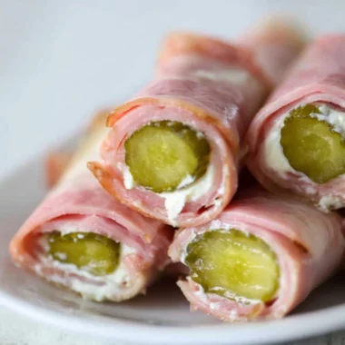 Ham and pickle roll-ups with cream cheese on a platter
