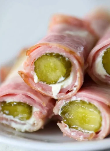 Ham and pickle roll-ups with cream cheese on a platter
