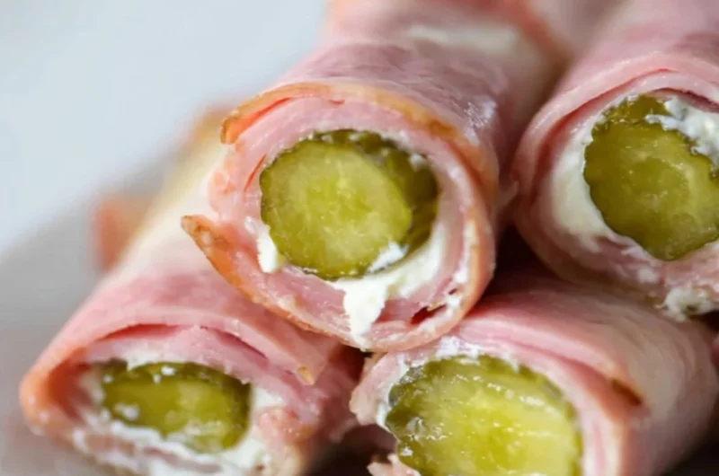 Ham and pickle roll-ups with cream cheese on a platter