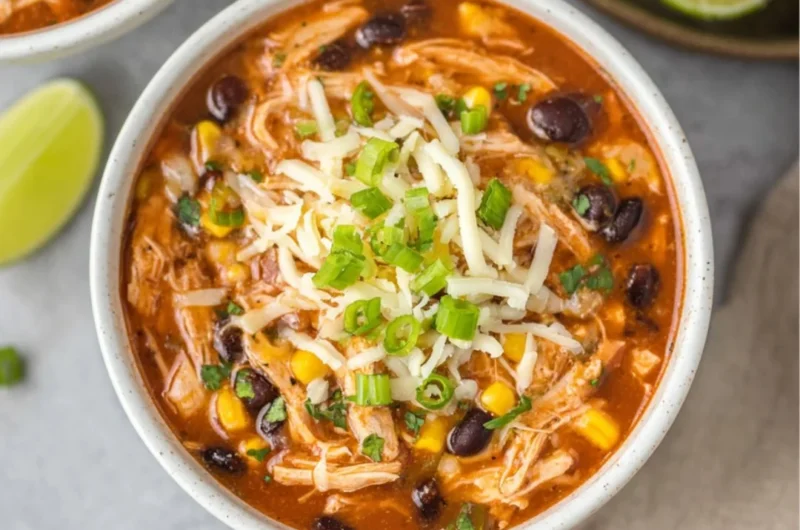Bowl of high protein chicken taco soup topped with avocado and cilantro