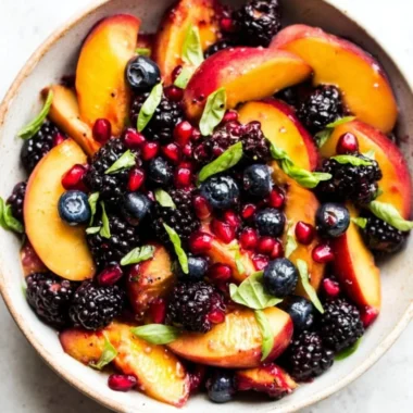 Delicious Honey Lime Basil Peach Fruit Salad served in a colorful bowl.
