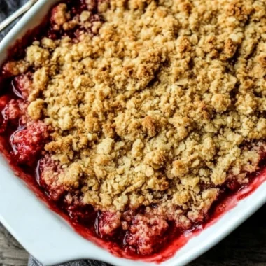 Old-Fashioned Strawberry Rhubarb Crisp with an oat topping in a rustic dish