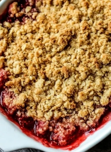 Old-Fashioned Strawberry Rhubarb Crisp with an oat topping in a rustic dish