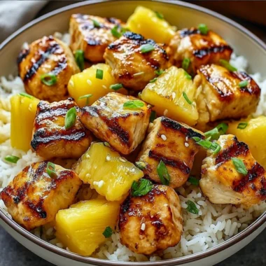 Delicious pineapple chicken served over fluffy rice garnished with fresh herbs.