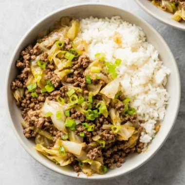 Beef and Cabbage Stir Fry in a colorful bowl on a wooden table.