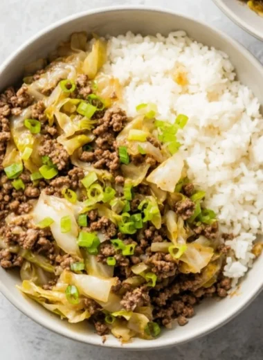 Beef and Cabbage Stir Fry in a colorful bowl on a wooden table.
