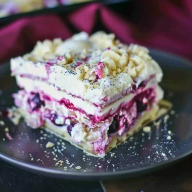 Blueberry cheesecake lasagna with layers of cream and fresh blueberries.