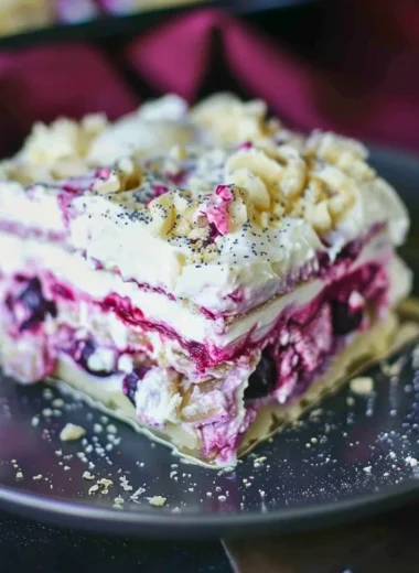Blueberry cheesecake lasagna with layers of cream and fresh blueberries.