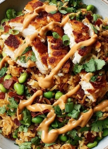 Chicken Crispy Rice Salad topped with peanut dressing in a vibrant bowl