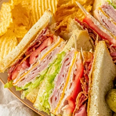 Delicious and layered Club Sandwich with turkey, bacon, and fresh veggies