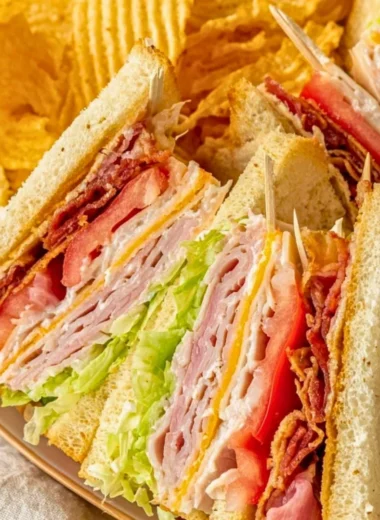 Delicious and layered Club Sandwich with turkey, bacon, and fresh veggies