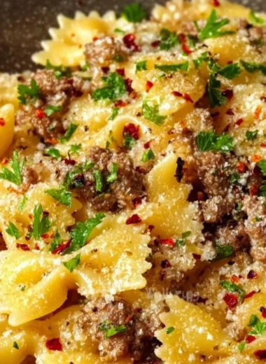 Plate of garlic butter bowtie pasta with ground beef garnished with parsley