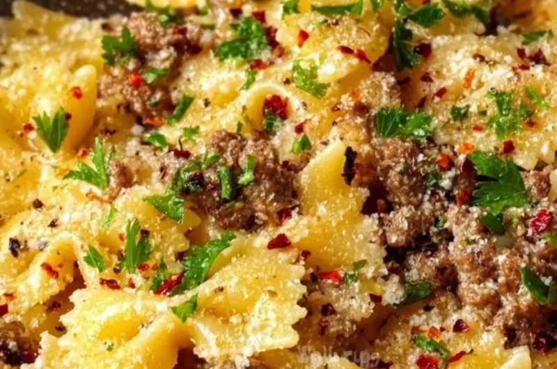 Plate of garlic butter bowtie pasta with ground beef garnished with parsley