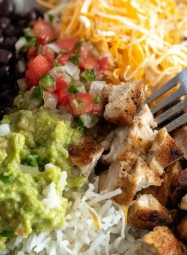 Grilled chicken burrito bowl with rice and beans, fresh ingredients, and vibrant colors.