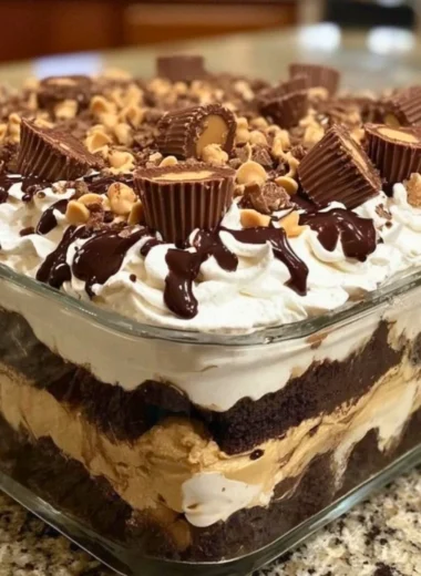 No-bake peanut butter chocolate dessert topped with chocolate drizzle and peanuts