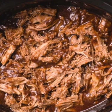 Delicious BBQ pulled pork made in a slow cooker, served with buns and coleslaw