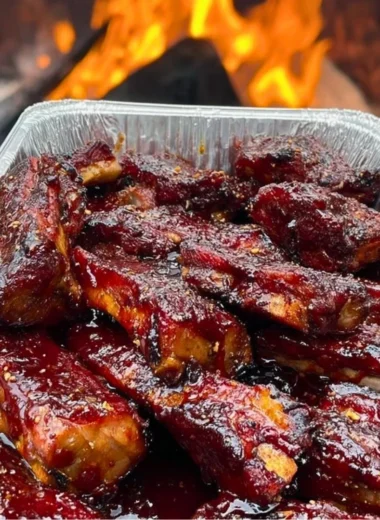 Delicious BBQ ribs on a plate, garnished with fresh herbs and sauces.