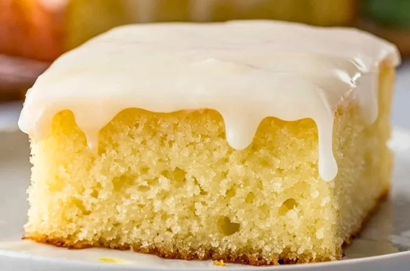 Delicious lemonade poke cake topped with fresh lemon slices and whipped cream
