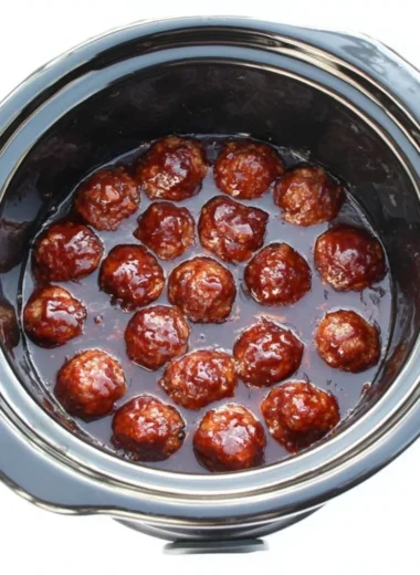 Delicious BBQ meatballs served on a plate with barbecue sauce.