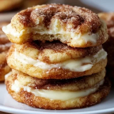 Cinnamon Roll Cheesecake Cookies arranged on a plate, drizzled with icing.