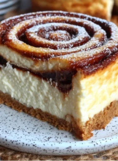 Delicious cinnamon roll honeybun cheesecake topped with icing and cinnamon