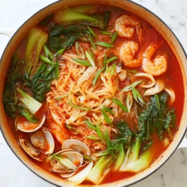 Delicious bowl of Korean seafood noodle soup with fresh ingredients and herbs