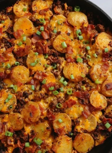 Loaded ground beef and potatoes skillet dish with cheese and vegetables.
